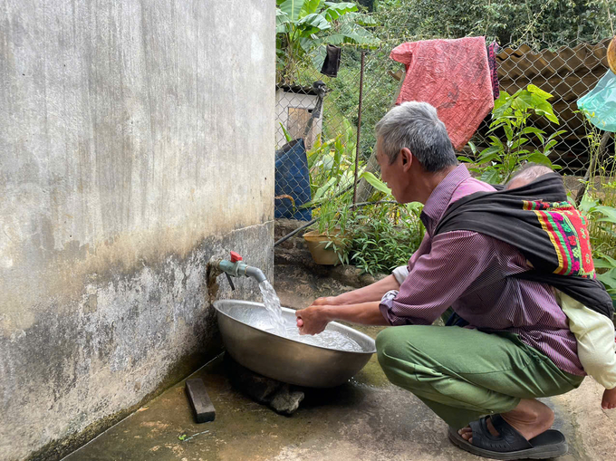 Ông Đặng Tuần Pin sử dụng nước từ công trình nước sạch mới được đầu tư. Ảnh: Trần Quản. 