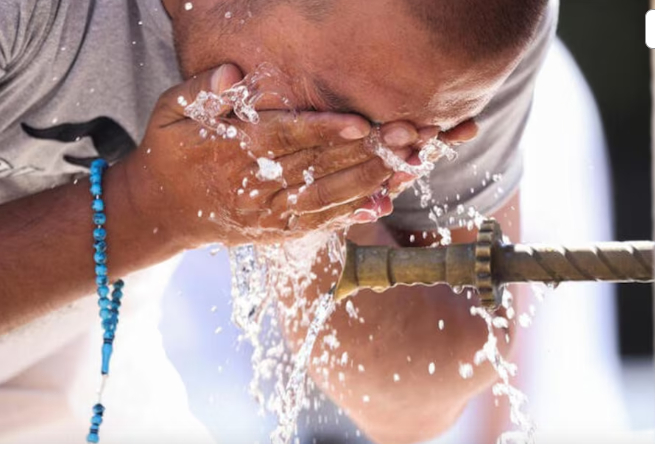 A tourist uses a fountain to cool off amid a heatwave, in Sarajevo, Bosnia and Herzegovina, August 13, 2024.