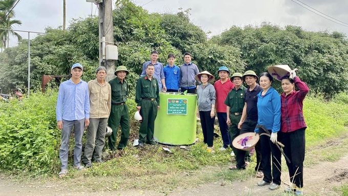 Bà con nhân dân phối hợp cùng các tổ chức đoàn thể sơn lại màu và gắn biển cho những bể thu gom Ảnh: Thanh Phương.