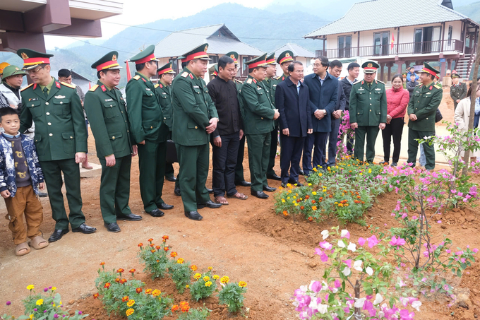 Thượng tướng Hoàng Xuân Chiến - Thứ trưởng Bộ Quốc phòng, cùng lãnh đạo Tỉnh ủy, UBND tỉnh Lào Cai thăm vườn hoa trước khuôn viên của một hộ dân tại khu tái định cư Làng Nủ. Ảnh: Kiên Trung.