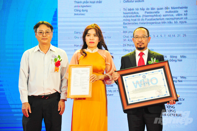 Mr. Dang Quoc Tuan, Deputy Director of the Central Veterinary Drug Testing Center II, representing the Department of Veterinary Medicine (left), presents the GMP-WHO certification for TOPCIN's veterinary and aquaculture pharmaceutical production plant. Photo: Le Hoang Vu. 