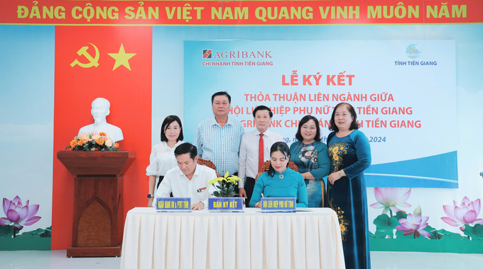 Giám đốc Trương Văn Đoàn (bên trái) đại diện Agribank Tiền Giang ký kết thỏa thuận với bà Nguyễn Thị Kim Phượng, Chủ tịch Hội Liên hiệp Phụ nữ tỉnh Tiền Giang (bên phải). Ảnh: Quốc Trí.