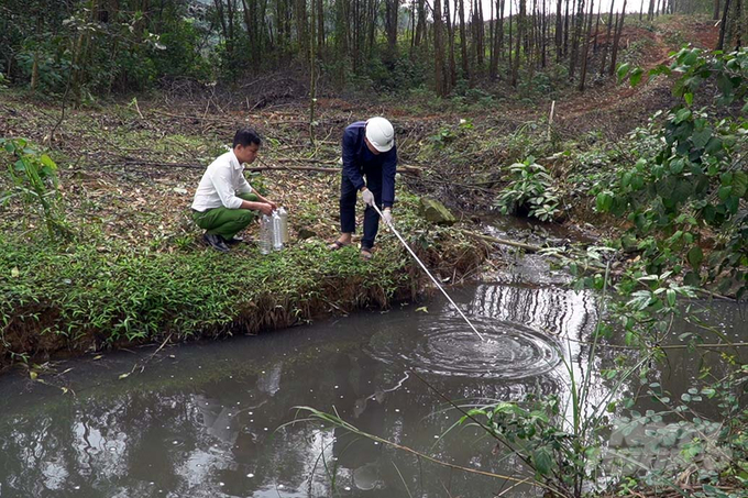 Sau phản ánh của người dân, cơ quan chức năng tỉnh Quảng Trị đã có mặt tại hiện trường, lấy mẫu nước tại nhiều điểm sau lưng trại lợn của ông Phạm Ngọc Lợi và điểm hợp lưu 2 dòng nước của 2 trại lợn để đem đi kiểm nghiệm. Ảnh: Võ Dũng.