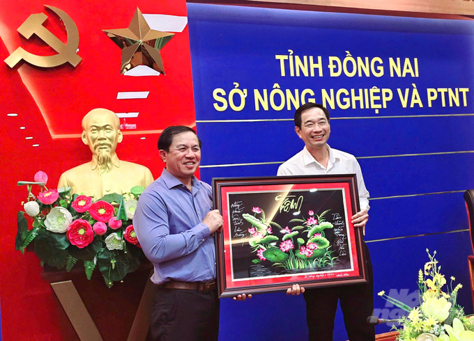 Lãnh đạo Sở NN-PTNT tỉnh Đồng Nai trao tặng tranh lưu niệm cho ông Võ Văn Phi, nguyên Phó Chủ tịch UBND tỉnh Đồng Nai tại buổi họp mặt cuối năm. Ảnh: Minh Sáng.