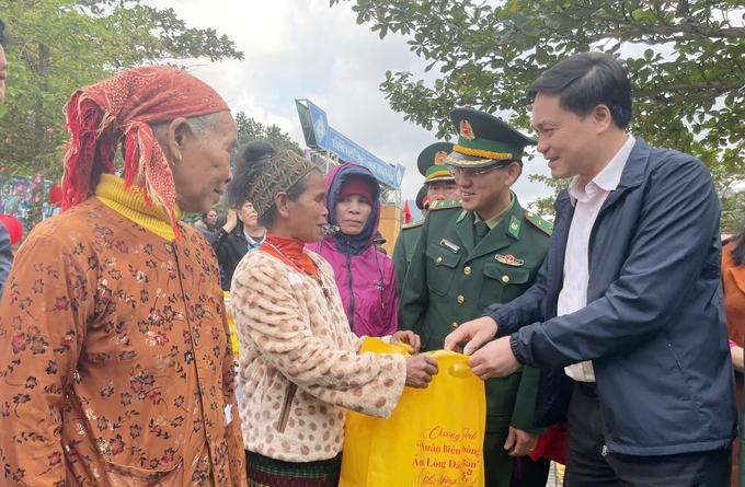 Ông Nguyễn Hữu Hán, Phó Chủ tịch UBND huyện Lệ Thủy (phải) và lãnh đạo Đồn Biên phòng Làng Ho tặng quà cho bà con dân bản. Ảnh: Đ.Trí.