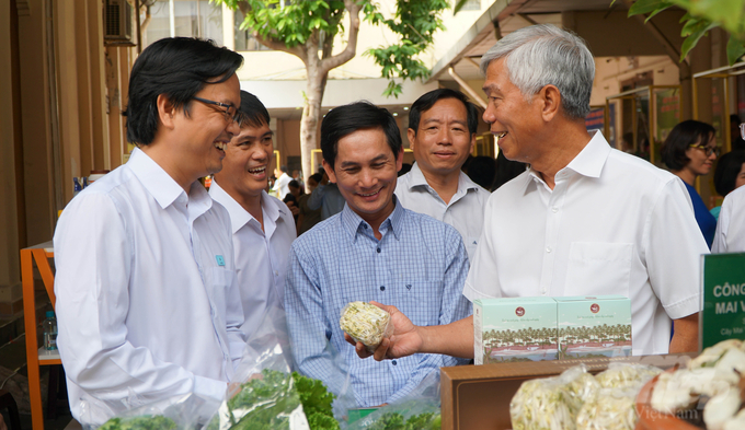 Ông Võ Văn Hoan, Phó Chủ tịch UBND TP.HCM (bìa phải) thăm và khá hài lòng với các sản phẩm 'xanh, sạch' của gian hàng HTX nông nghiệp Tuấn Ngọc. Ảnh: Lê Bình.