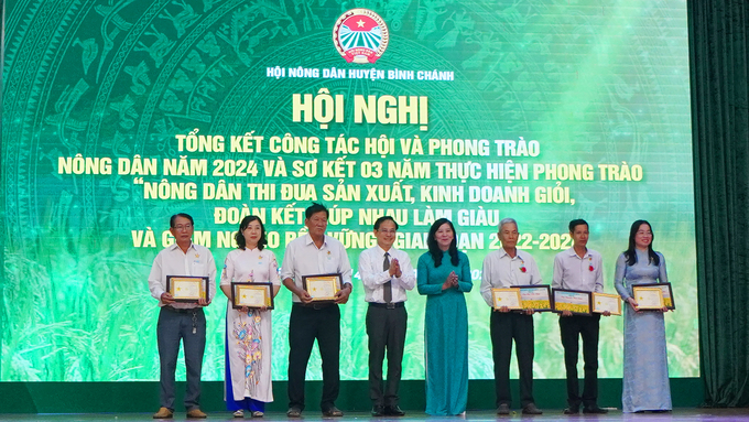 Bà Huỳnh Thị Kim Xuyến, Phó Chủ tịch Hội Nông dân TP.HCM và ông Phạm Văn Lũy, Phó Bí thư Thường trực Huyện ủy, Chủ tịch Hội đồng nhân dân huyện Bình Chánh trao kỷ niệm chương 'Vì giai cấp Nông dân Việt Nam' cho các cá nhân, tập thể. Ảnh: Nguyễn Thủy.