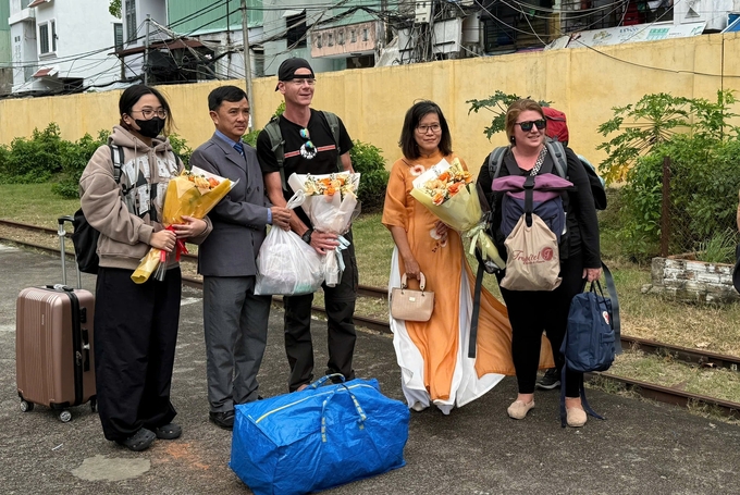 Bà Nguyễn Thị Kim Chung, Phó Giám đốc Sở Du lịch Bình Định (thứ 2 từ phải sang) chào mừng, tặng hoa những khách du lịch nước ngoài đến Bình Định bằng đường tàu hỏa. Ảnh: V.Đ.T.