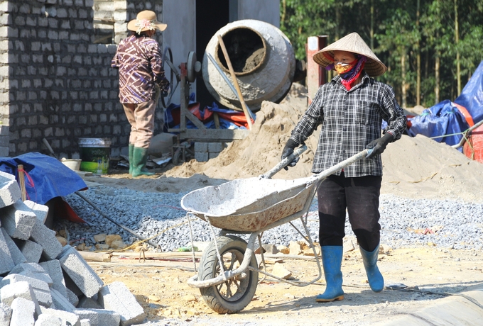 Ai ai cũng tất bật, luôn chân luôn tay để kịp tiến độ xây dựng tại khu tái định cư xóm Liên Phương. Ảnh: Phạm Hiếu.