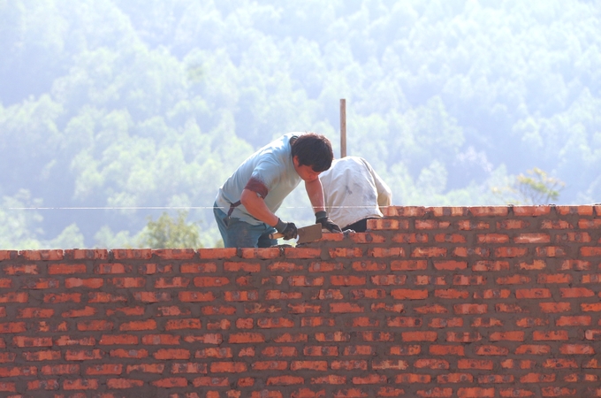 Người dân xã Văn Lăng cẩn thận đặt từng viên gạch cho ngôi nhà mới. Ảnh: Phạm Hiếu.