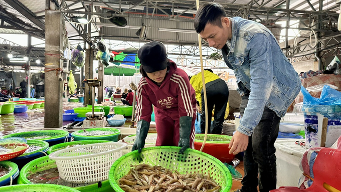 Chị Vũ Thị Thúy (tiểu thương bán hải sải tại chợ Hạ Long 1) cùng khách chọn mua tôm. Ảnh: Thanh Phương.