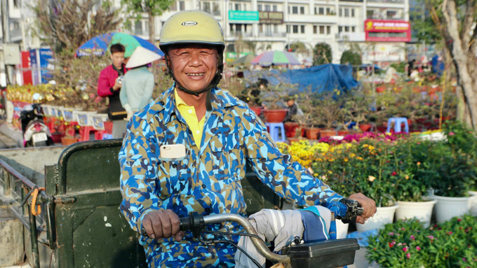 Ông Vũ Văn Tịnh tranh thủ làm tài xế vận chuyển cây cảnh ngày cận Tết. Ảnh: Thanh Phương. 