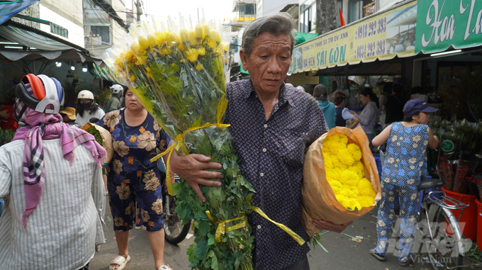 Các tiểu thương nhiệt tình giới thiệu các loại hoa tươi mới, từ những cành hoa đào tươi đến những chậu hoa cúc, hoa mai. Cảnh tượng trao đổi nhanh chóng giữa người bán và người mua tạo nên không khí đặc trưng của một chợ hoa ngày Tết.