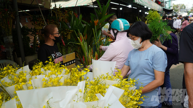 Bà Nguyễn Thị Lan đi chợ hoa Hồ Thị Kỷ mua 3 bó cúc lưới. Bà cho biết hầu như năm nào chị cũng ghé đây để cảm nhận được không khí tết. 'Mỗi bó giá 50.000 đồng, giá cũng mềm hơn so với mọi năm.