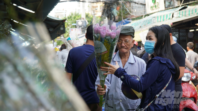 Các khách hàng, từ người già đến trẻ nhỏ, đều háo hức chọn những loài hoa yêu thích để mang về đón Tết. Những nụ cười rạng rỡ, những ánh mắt tươi vui phản ánh không khí ấm áp, hạnh phúc trong những ngày cuối năm.