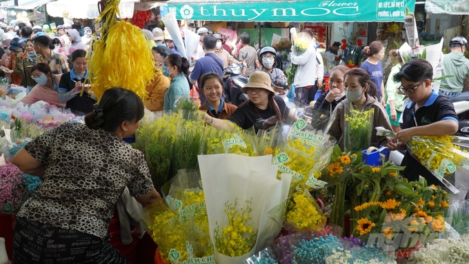 Cảnh mua bán diễn ra vô cùng nhộn nhịp, những tiểu thương nhanh tay đóng gói hoa cho khách, kịp thời giao hàng trước đêm Giao thừa.