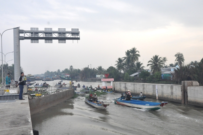 Các phương tiện thủy được điều tiết lưu thông qua cửa âu khi cống vàm Bà Lịch được đóng để kiểm soát mặn xâm nhập sâu vào nội đồng. Ảnh: Trung Chánh.