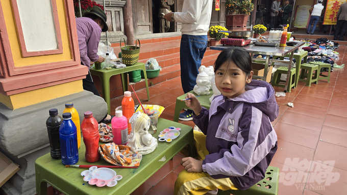 Một bé gái thích thú được tô tượng...