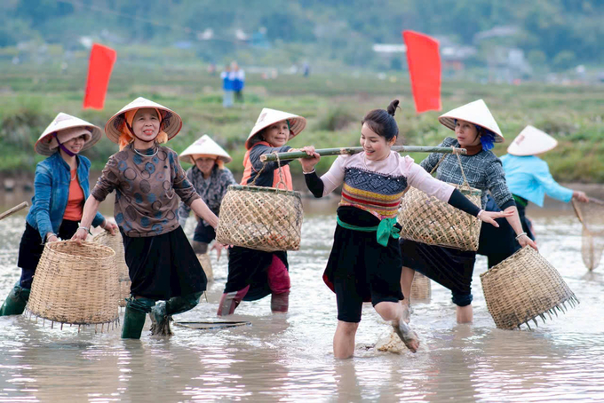 Hoạt động bắt cá tái hiện đời sống thường ngày của người dân và tạo khí thế thi đua sản xuất trong năm mới. Ảnh: Thanh Tiến.