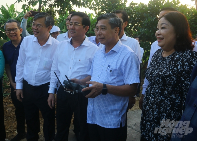 Ông Đồng Văn Thanh (thứ 2 hàng đầu từ phải sang) trải nghiệm điều khiển thiết bị bay không người lái phục vụ sản xuất lúa. Ảnh: Trung Chánh.