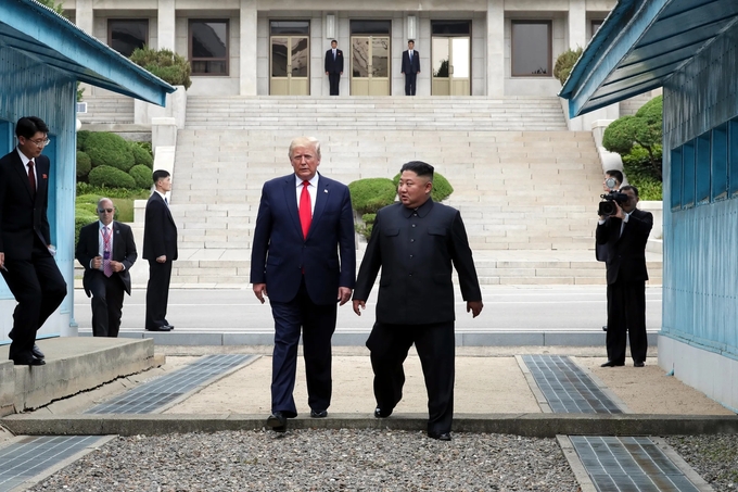 Tổng thống Mỹ Donald Trump và nhà lãnh đạo Triều Tiên Kim Jong-un bước qua vùng phi quân sự ở Panmunjom, Hàn Quốc. Ảnh: Getty.