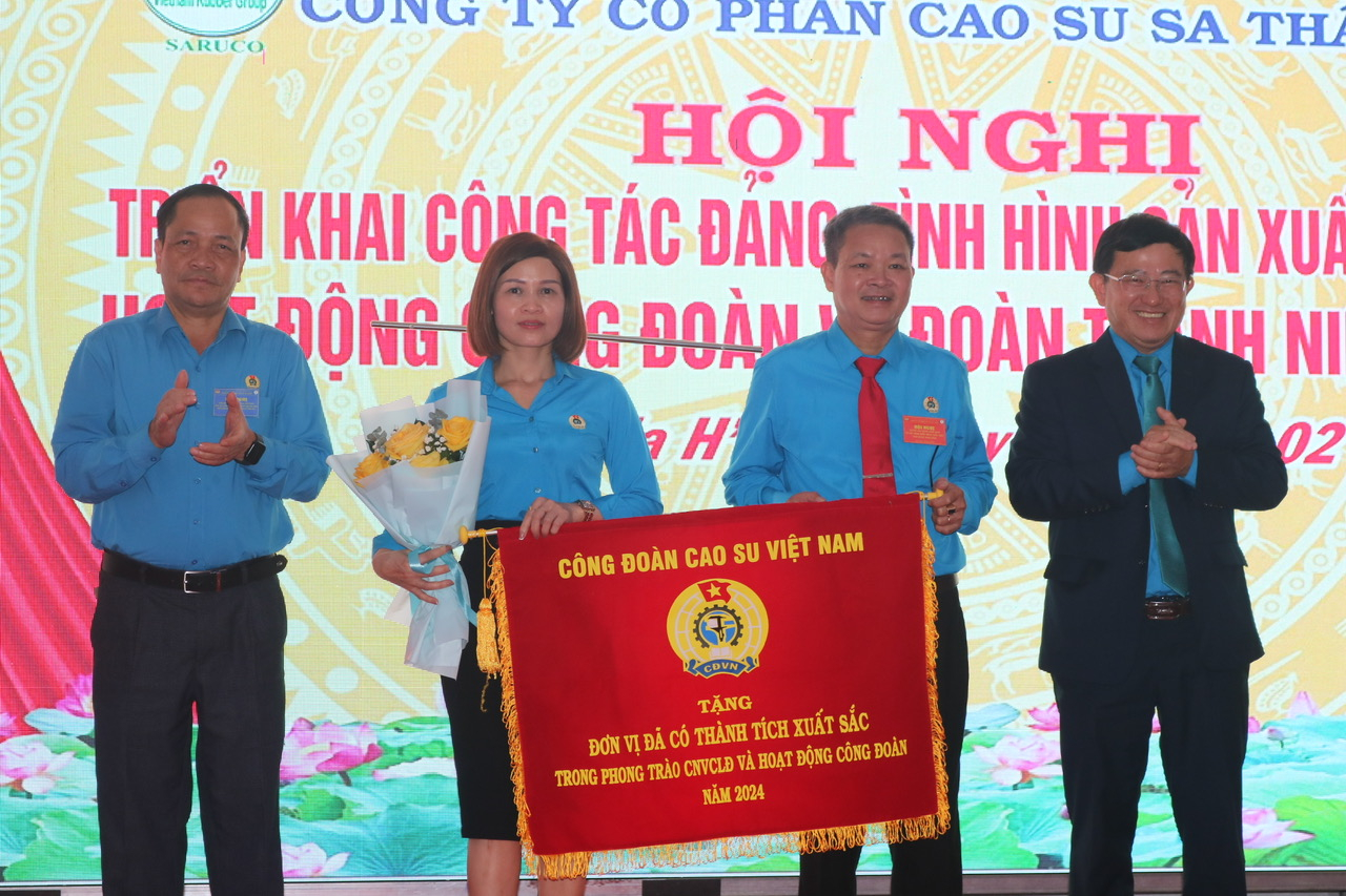 Lãnh đạo Tập đoàn Công nghiệp Cao su Việt Nam và Liên đoàn Lao động tỉnh Kon Tum tặng cờ thi đua của Tổng Liên đoàn Lao động Việt Nam cho Công ty Cao su Sa Thầy. Ảnh: Ngọc Thăng.