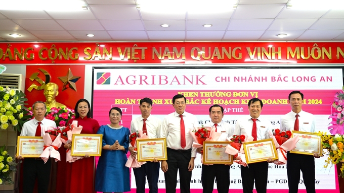 Lãnh đạo NHNN chi nhánh tỉnh Long An và Agribank chi nhánh Bắc Long An tặng giấy khen và hoa cho các đơn vị hoàn thành xuất sắc kế hoạch kinh doanh năm 2024. Ảnh: Minh Hùng.