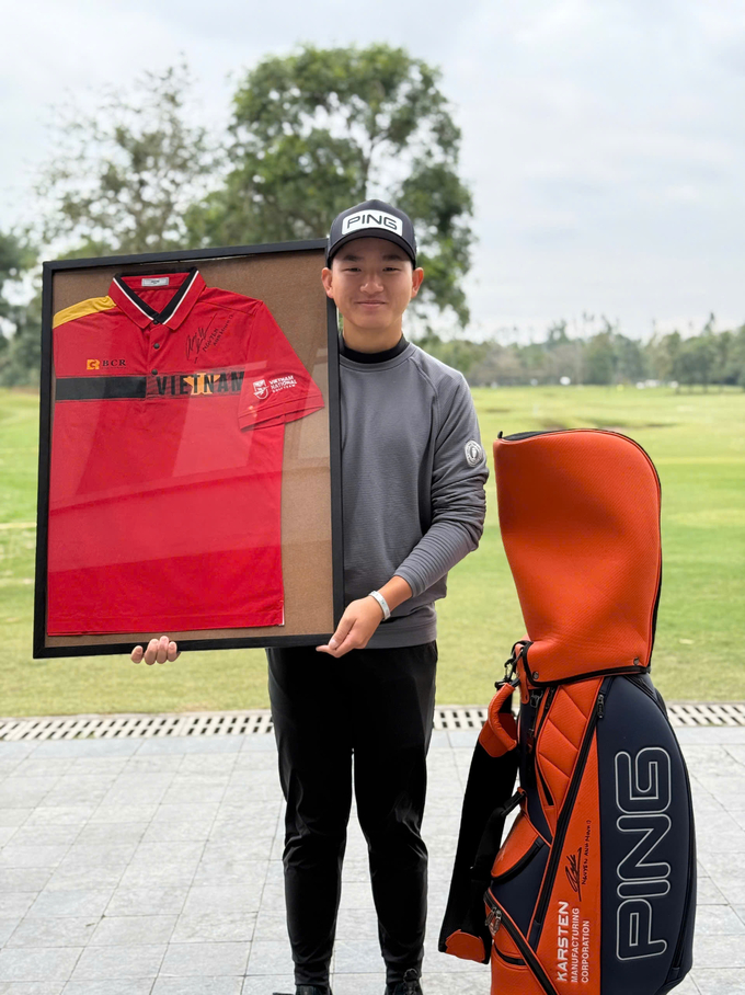 Golf thủ Nguyễn Anh Minh bên hiện vật đấu giá.