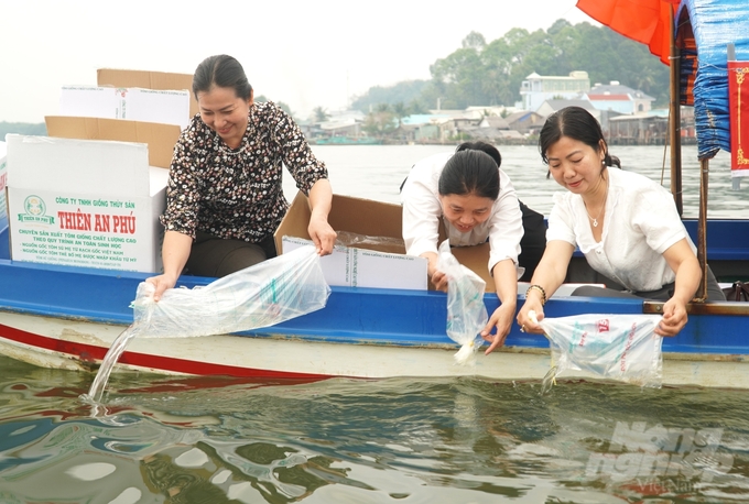 Các đại biểu tham gia thả con giống tại đầm Đông Hồ nhằm tái tạo nguồn lợi thủy thủy sản. Ảnh: Trung Chánh.