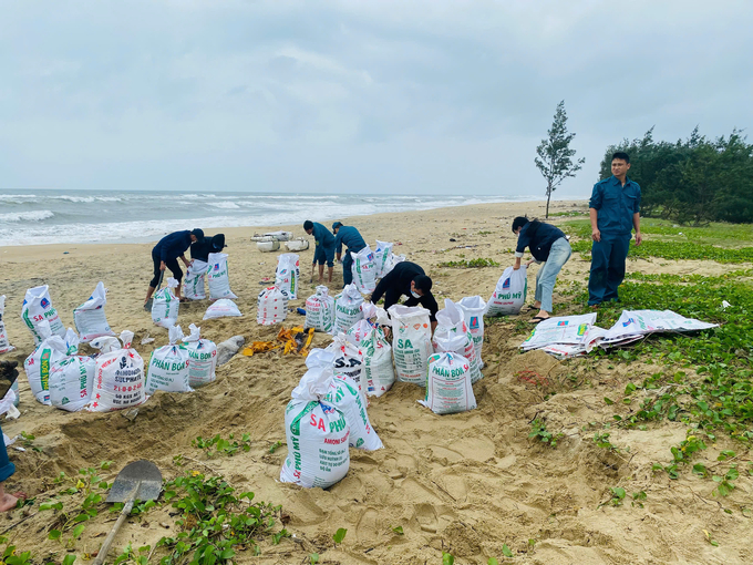 Chính quyền địa phương đã huy động lực lượng sử dụng bao cát để chắn sóng tạm thời. Ảnh: L.K.