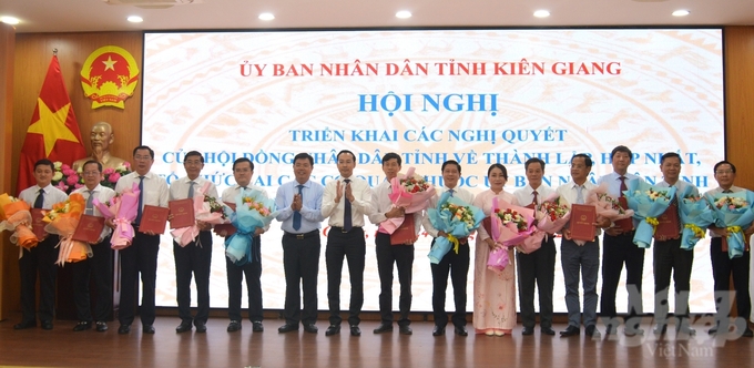 Bí thư Tỉnh ủy Kiên Giang Nguyễn Tiến Hải (thứ 6 từ trái qua) và Chủ tịch UBND tỉnh Kiên Giang Nguyễn Thanh Nhàn (thứ 7 từ trái qua) trao quyết định và tặng hoa chúc mứng các lãnh đạo sở mới được thành lập, hợp nhất. Ảnh: Trung Chánh. 