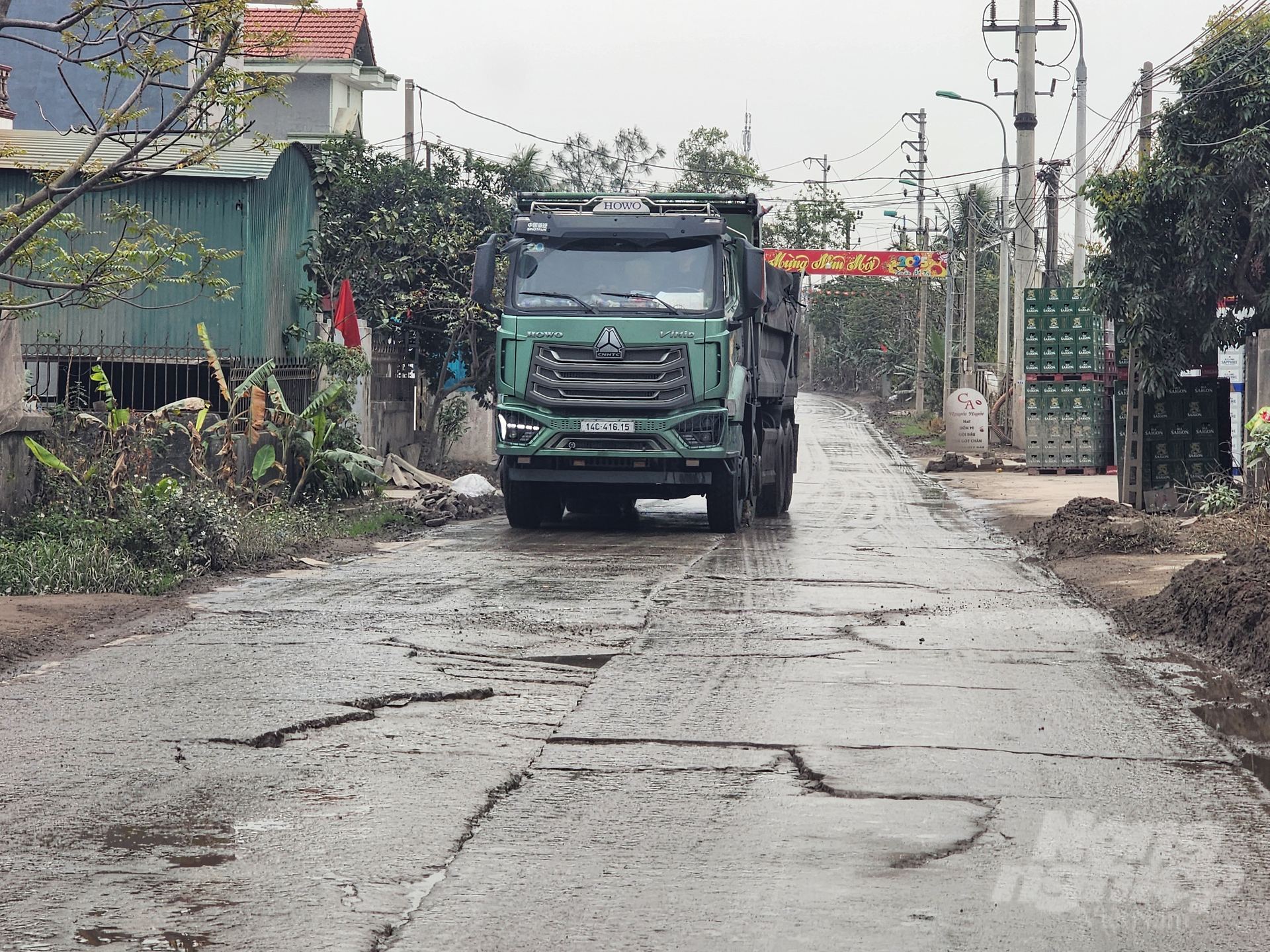 Cách đây một năm, phóng viên từng đi vào con đường này nhưng khi đó đường còn khá bằng phẳng. Sau một năm, nhiều xe vận tải đất đá, tro xỉ chạy qua khiến nhiều đoạn đường hư hỏng nặng. Ảnh: Cường Vũ.