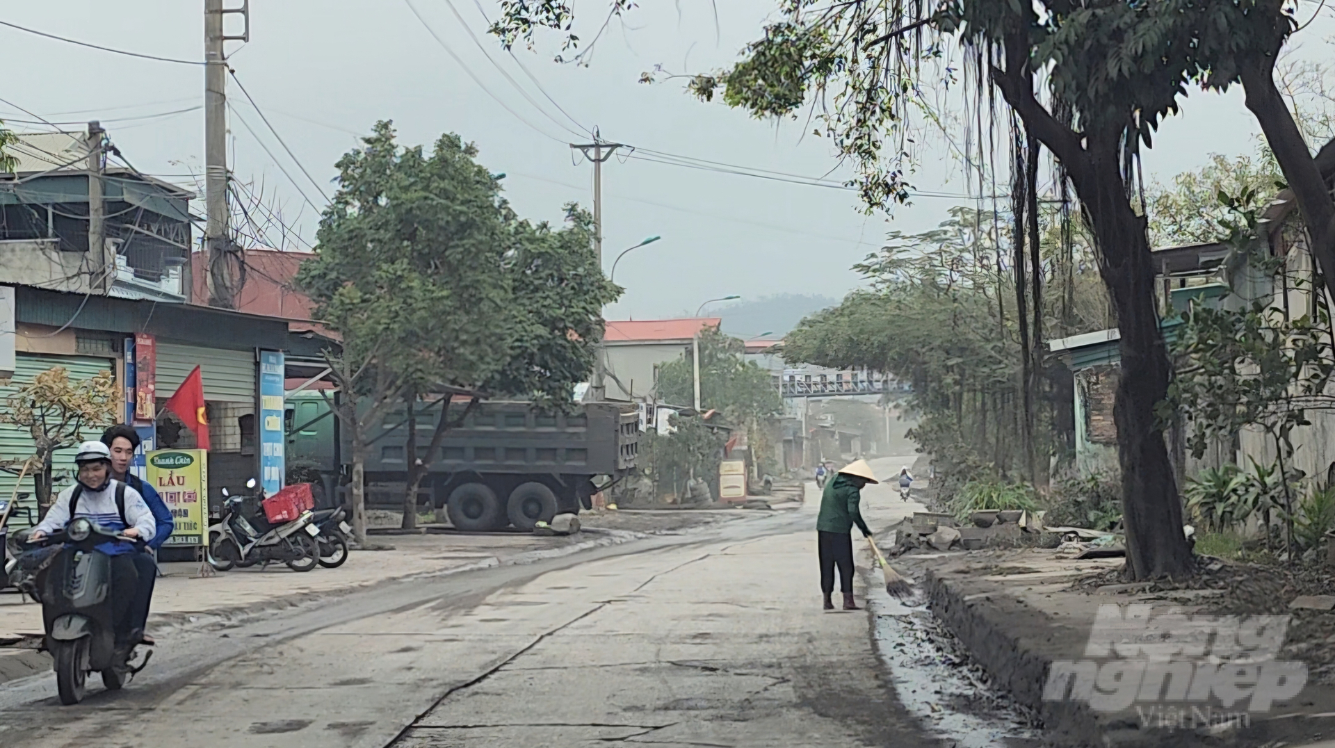 Theo các công nhân vệ sinh môi trường, việc tưới nước giảm bụi hay quét dọn đất cát trên đường không kịp với lượng rơi vãi thêm mỗi ngày. Ảnh: Cường Vũ.