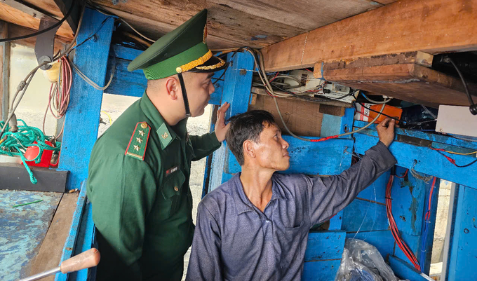 The Border Guards inspect the vessel monitoring equipment on a fishing boat. Photo: KS.