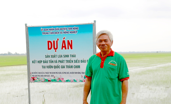 Ông Nguyễn Văn Mẫn bên mô hình sản xuất lúa sinh thái kết hợp bảo tồn và phát triển sếu tại Vườn quốc gia Tràm Chim. Ảnh: Lê Hoàng Vũ.