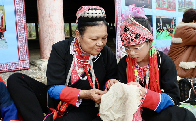 Nghệ nhân Trương Thị Đông hướng dẫn cách thêu truyền thống cho thế hệ trẻ. Ảnh: Thanh Phương.