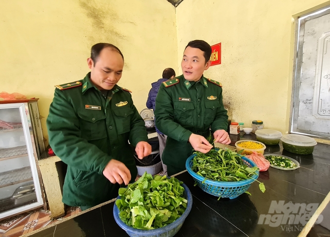 Chính trị viên phó Nguyễn Thành Luận (bìa phải) cùng những người lính Đồn biên phòng Thàng Tín đến giúp cô, trò điểm trường Cáo Phìn Một, Trường Mầm non Thèn Chu Phìn, xã Thèn Chu Phìn nấu ăn trưa. Ảnh: Đào Thanh.