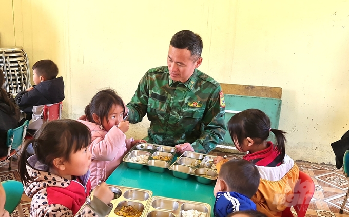 Phó Đồn trưởng Đồn biên phòng Thàng Tín Nguyễn Hữu Hoàng hỏi thăm, động viên các em học sinh tại điểm trường Cáo Phìn 1, Trường Mầm non Thèn Chu Phìn. Ảnh: Đào Thanh.