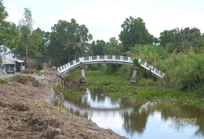 Một cây cầu giao thông nông thôn bắc qua tuyến kênh thuộc hệ thống đê bao ngoài bị sạt lở đất làm biến dạng, sụp mố hai bên, không còn khả năng sửa chữa để sử dụng. Ảnh: Trung Chánh.