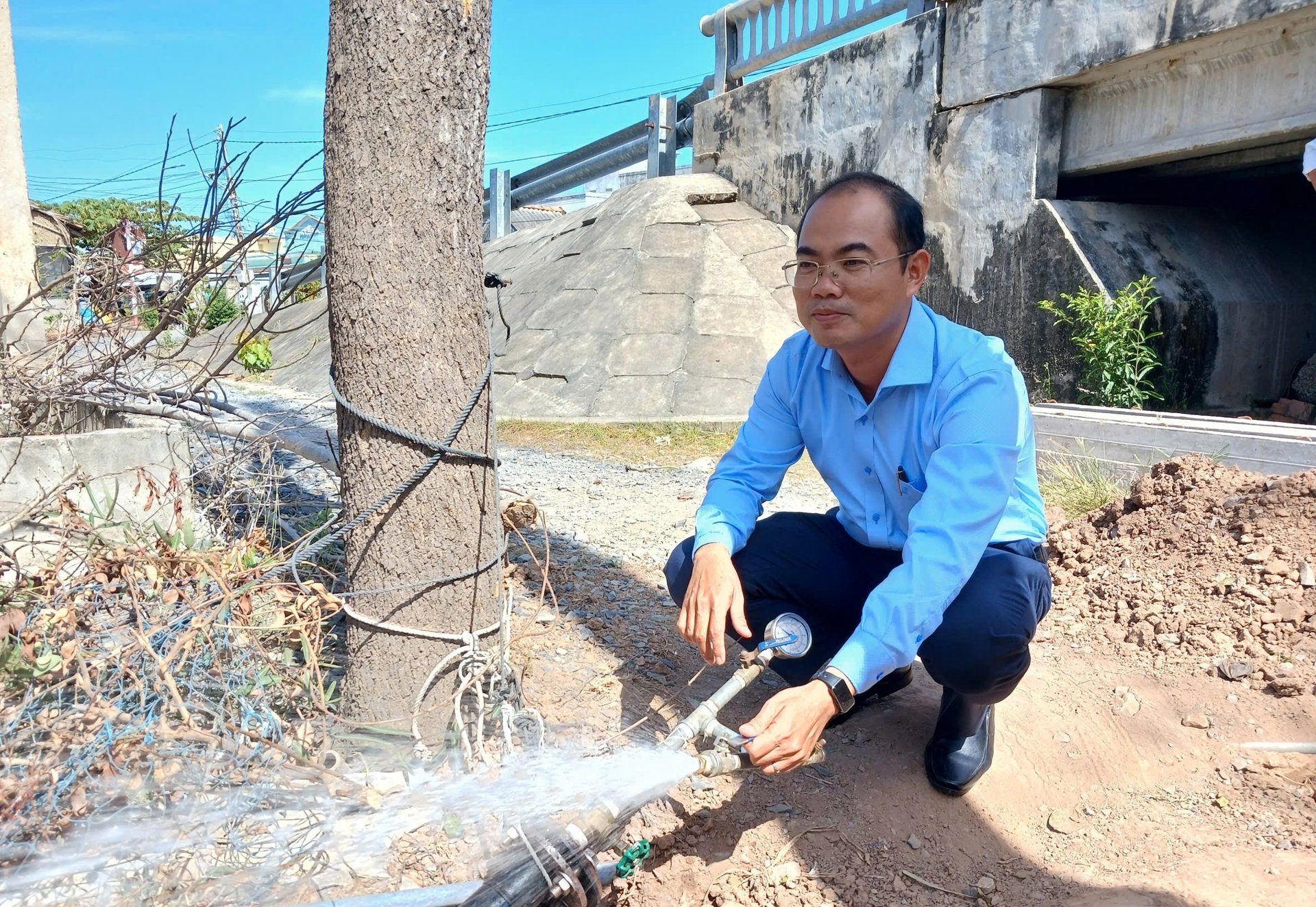 Ông Nguyễn Đức Thịnh kiểm tra áp lực nước tại các tuyến đường ống vừa mới được đầu tư. Ảnh: Minh Đảm.