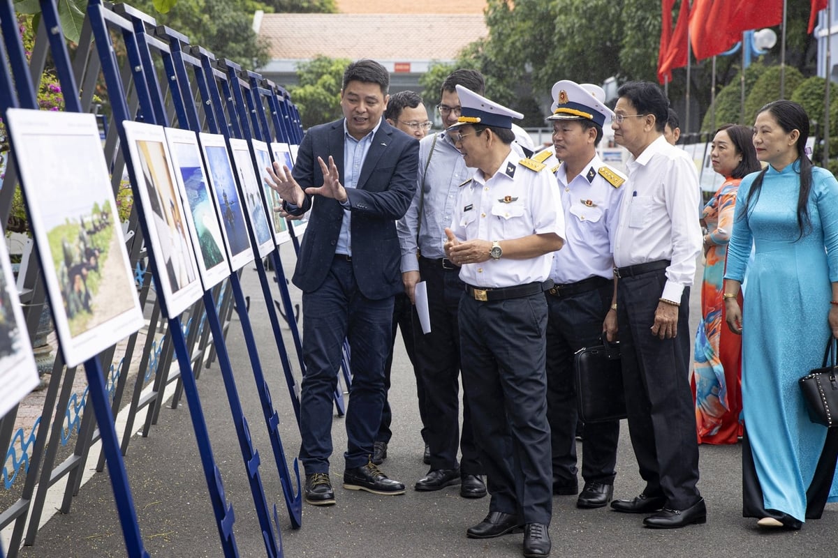 Đại diện CLB Phóng viên ảnh Hà Nội giới thiệu về các tác phẩm của thành viên câu lạc bộ với cán bộ, chiến sỹ Vùng 4 Hải quân. Ảnh: CLB Phóng viên ảnh Hà Nội.