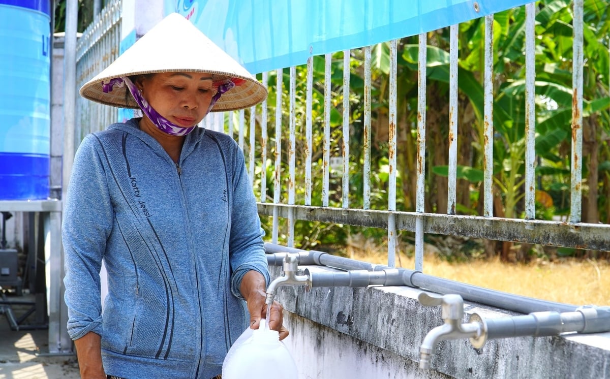 Người dân phấn khởi sử dụng nguồn nước sạch từ Hệ thống máy lọc nước mặn. Ảnh: Kim Anh.