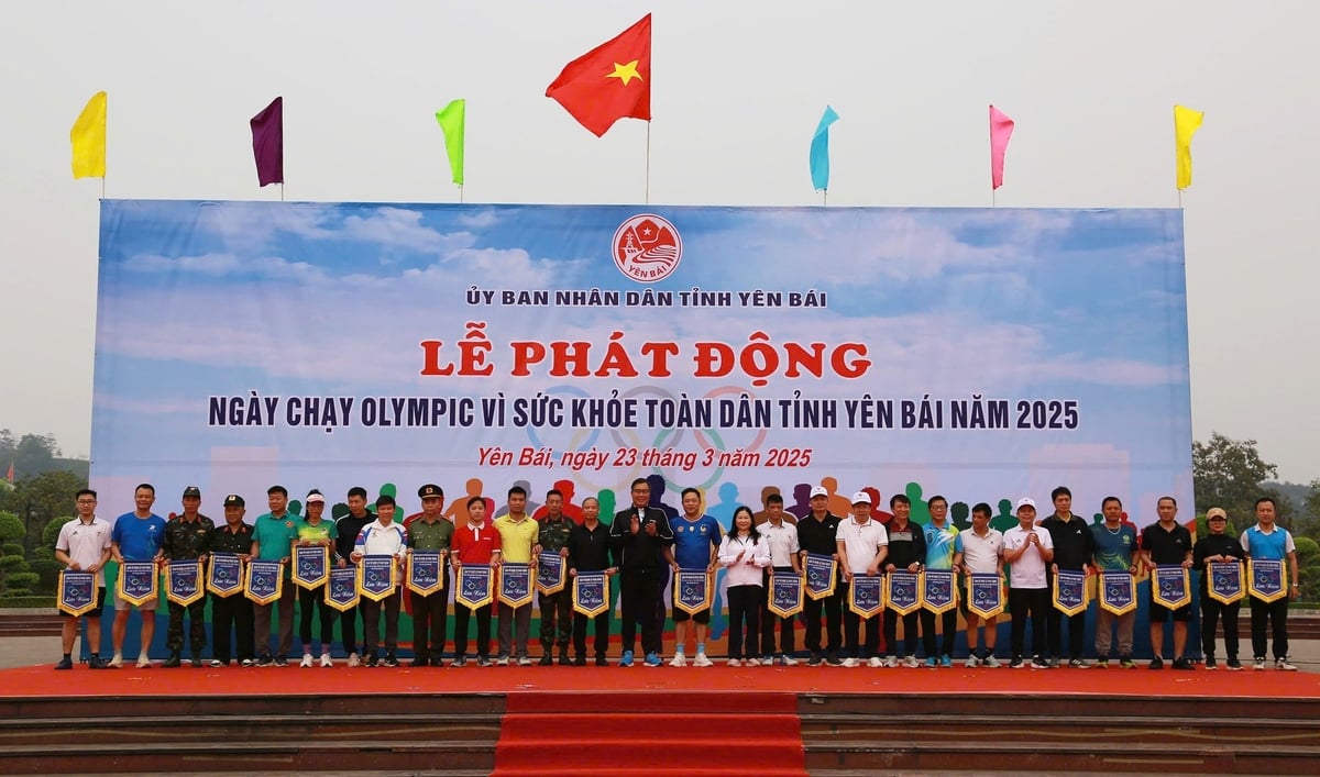 Lãnh đạo tỉnh và Ban tổ chức tặng cờ lưu niệm cho các đội tham gia Ngày chạy Olympic vì sức khỏe toàn dân năm 2025. Ảnh: Thanh Ngà.