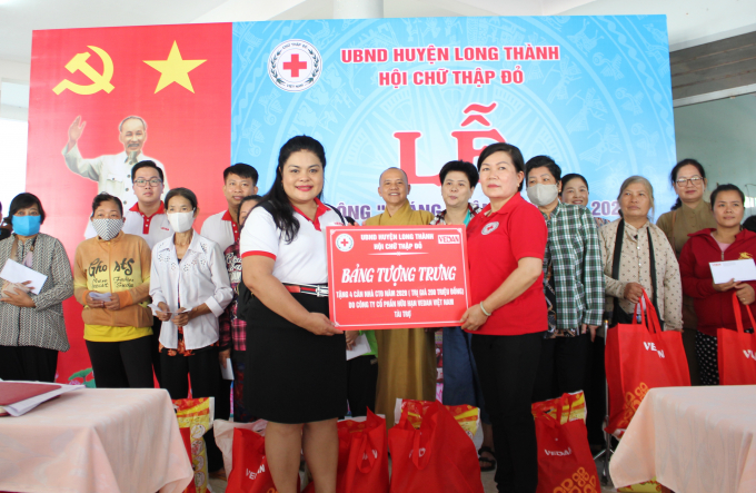 Bà Nguyễn Thu Thủy - đại diện Vedan trao bảng tượng trưng 4 căn nhà cho đại diện Hội Chữ thập đỏ huyện Long Thành, tỉnh Đồng Nai. Ảnh: VĐ.