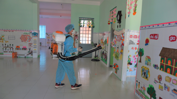 Đội ngũ Trung tâm y tế dự phòng phun xịt thuốc chống dịch tại trường mẫu giáo.
