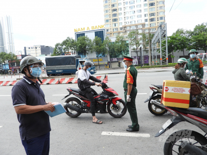 Tại chốt kiểm soát vòng xoay Điện Biên Phủ - Nguyễn Bỉnh Khiêm, Quận 1, một số người có giấy tờ ra đường hợp lệ được lưu thông đúng tuyến quy định. Anh Nguyễn Công Hùng, cán bộ Bộ Chỉ huy quân sự TP.HCM cho biết, người dân chấp hành quy định giãn cách rất tốt, trong cả buổi sáng 23/8, chốt chưa phát hiện trường hợp nào ra đường trái quy định. Ảnh: Hồng Thủy.