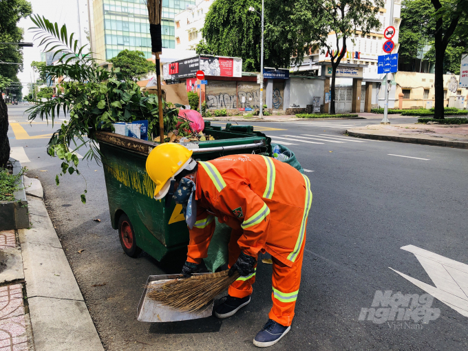 Gần đó, chỉ có chị lao công vẫn miệt mài làm việc, xung quanh vắng lặng như tờ. Ảnh: Minh Sáng.