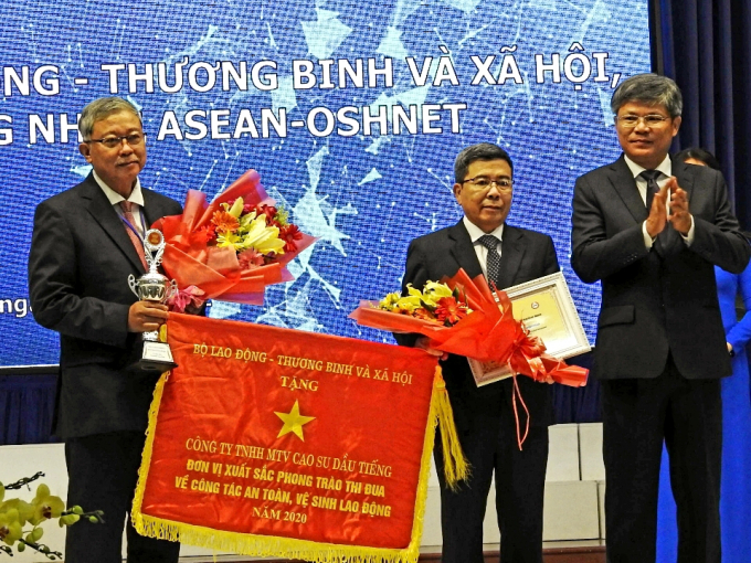 Ông Nguyễn Quốc Việt - Tổng Giám đốc, đại diện Công ty cao su Dầu Tiếng nhận Cờ Bộ LĐTBXH và Cúp, Giấy chứng nhận ASEAN về ATVSLĐ.