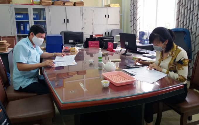Cán bộ Phòng LĐ-TB&XH TP Cẩm Phả đối chiếu, rà soát danh sách các đối tượng thụ hưởng chính sách hỗ trợ. Ảnh: Báo Quảng Ninh.
