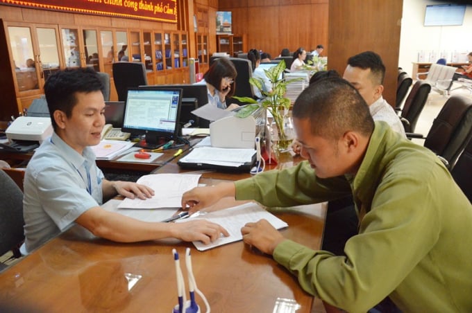 Cán bộ Trung tâm Hành chính công TP Cẩm Phả (Quảng Ninh) hướng dẫn công dân giải quyết thủ tục hành chính. Ảnh: Nguyễn Thanh